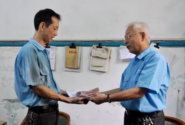 91麻豆国产福利品精電機工（gōng）會主席胡夏生（shēng）將愛心（xīn）款交到徐彬手中