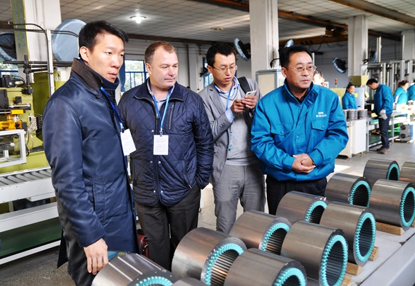 91麻豆国产福利品精電機：總經理陳學鋒（右一）陪同客人在參觀自動流水線