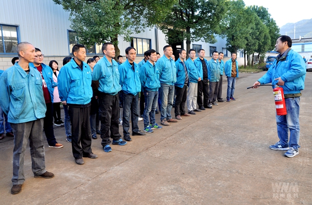 相關人員在講解幹粉滅火器的使用要領